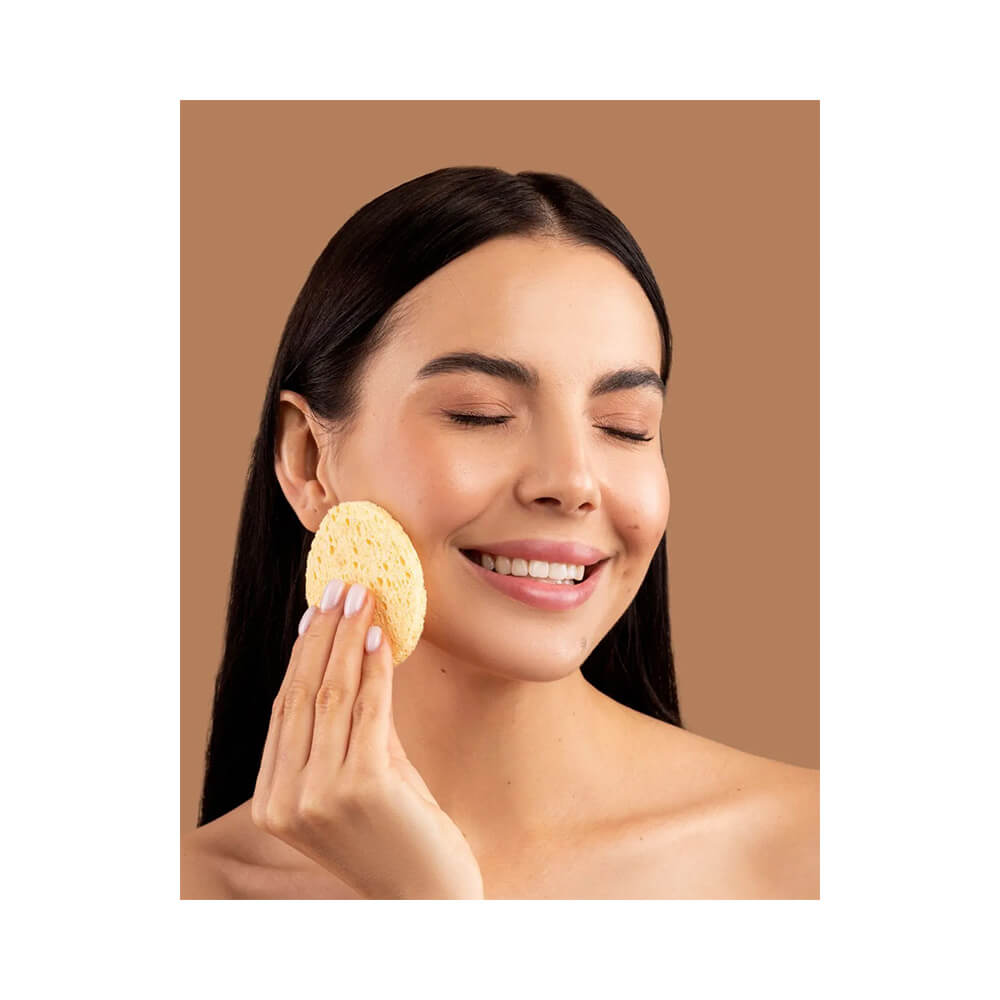 Mulher usando esponja facial amarela Landh's para limpeza do rosto
